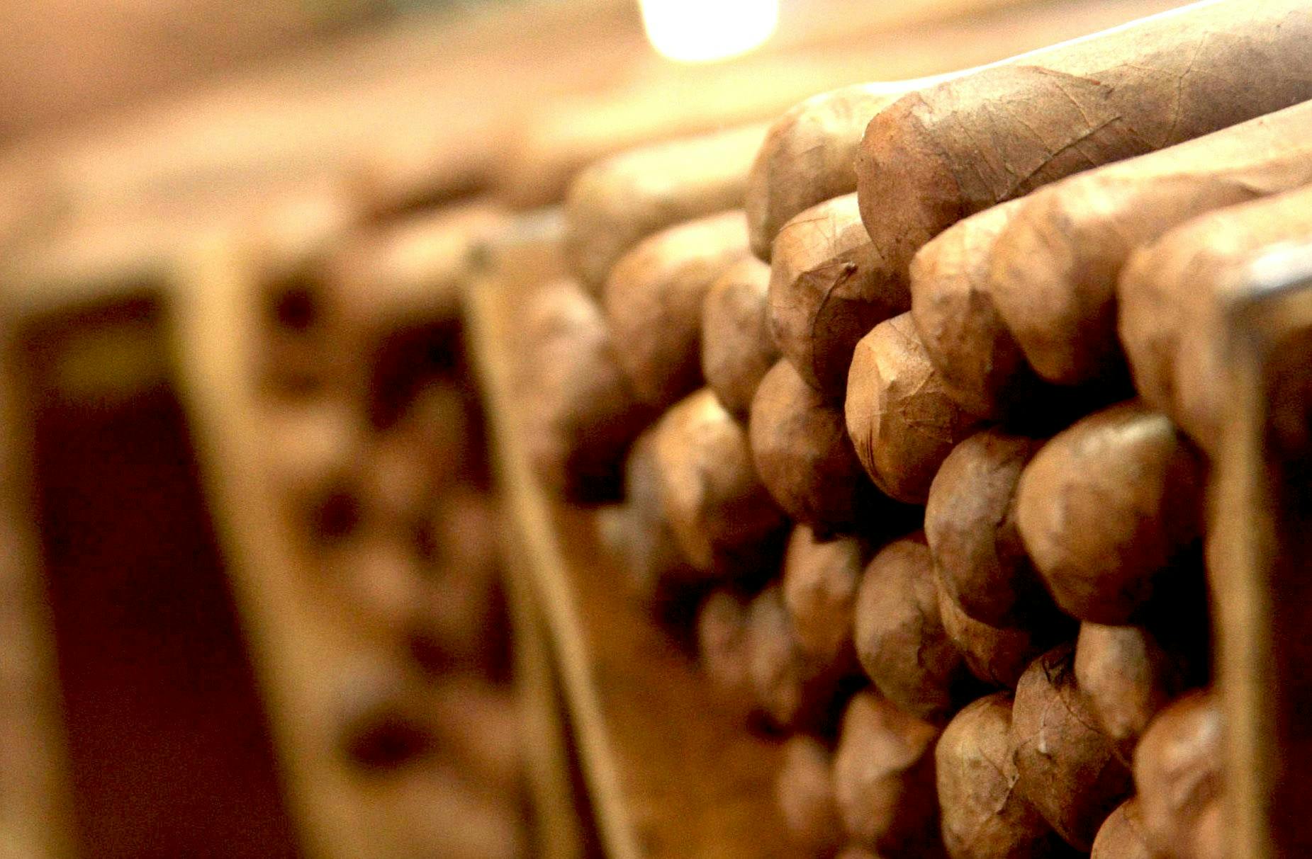 Stack of cigars on wooden shelf